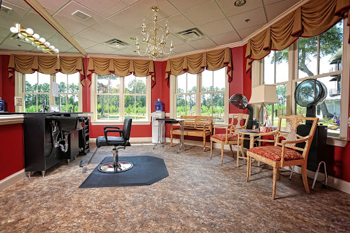 A stylish salon waiting area featuring comfortable seating, large windows with scenic views, and a modern chandelier.