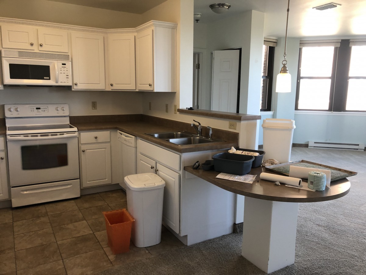 A modern kitchen interior featuring white cabinets and standard appliances.