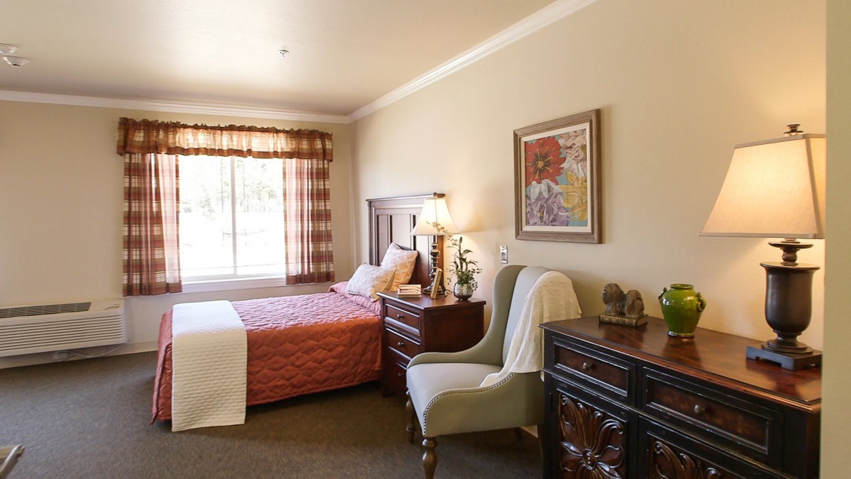 A cozy bedroom with elegant furnishings and a large window allowing natural light.