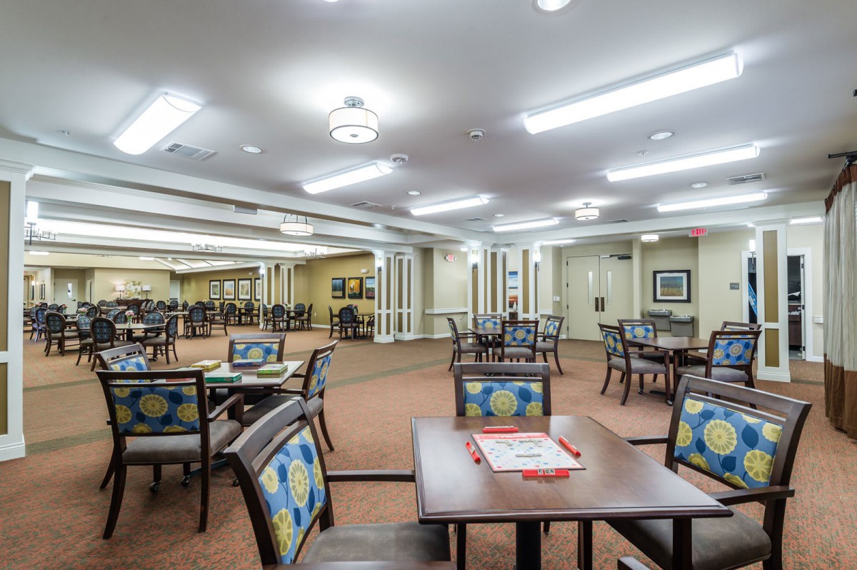 A spacious and well-lit dining area with neatly arranged tables and chairs.