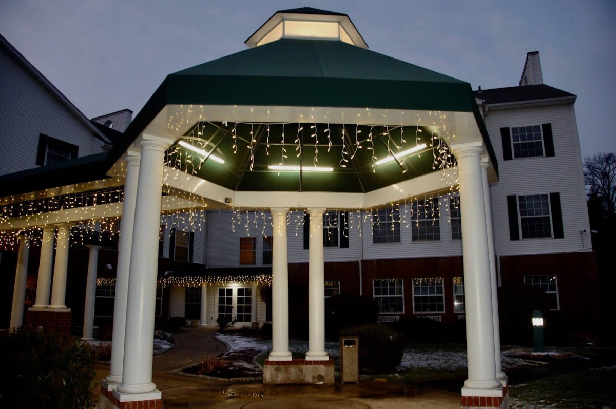 A lit gazebo with hanging lights in the evening.