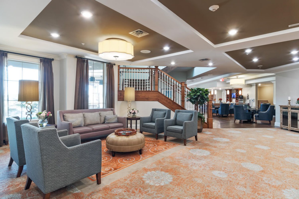 A spacious and elegant lounge area with comfortable seating and a staircase.