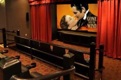 An empty movie theater screen showing 'Gone with the Wind'.