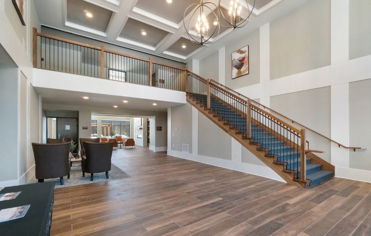 A modern interior with a grand staircase and elegant chandelier.