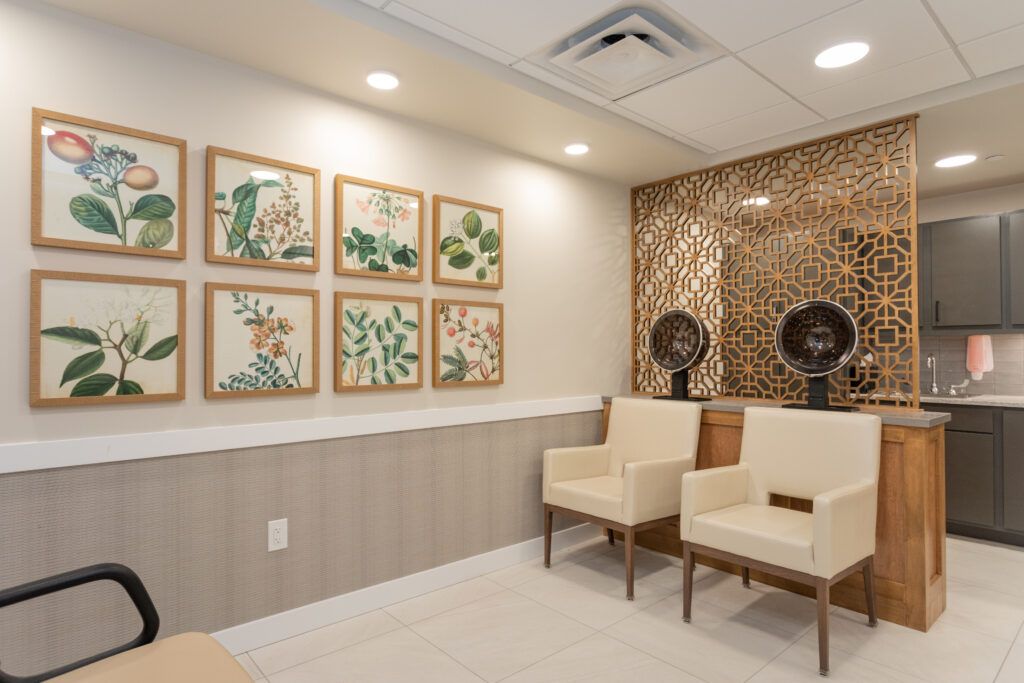 A well-designed waiting room with framed artwork and beige chairs.