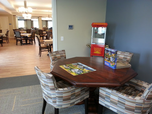 A cozy dining area featuring a round table with comfortable chairs and a vintage popcorn machine.