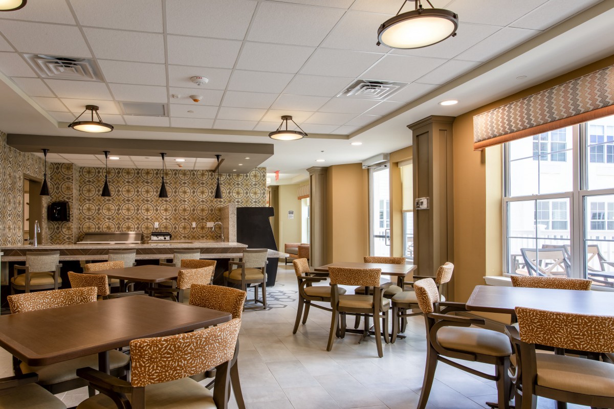 A spacious restaurant dining area with tables, chairs, and ambient lighting.