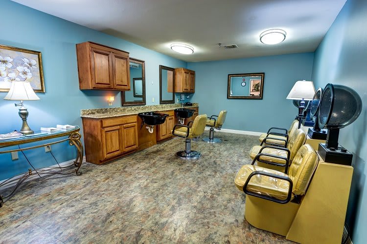 A modern salon interior with styling chairs, mirrors, and a hair washing station.