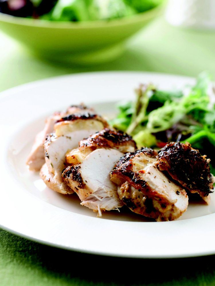 A plate of roasted chicken with fresh greens.