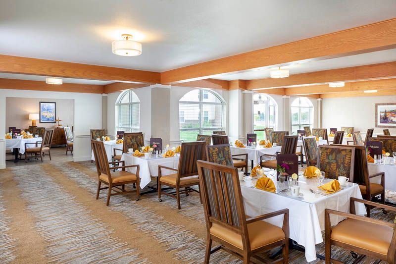 A well-decorated dining area with elegantly set tables and wooden chairs.