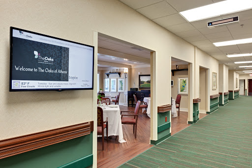 A view of a dining area featuring tables and chairs, with a television screen on the wall.