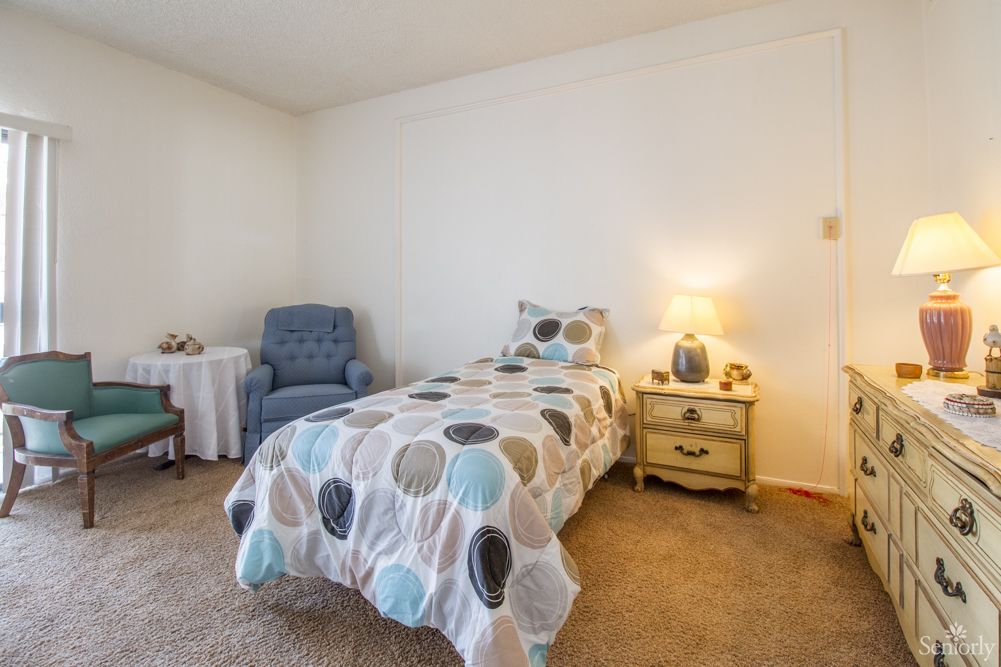 A cozy bedroom with a single bed and nightstand lamp.