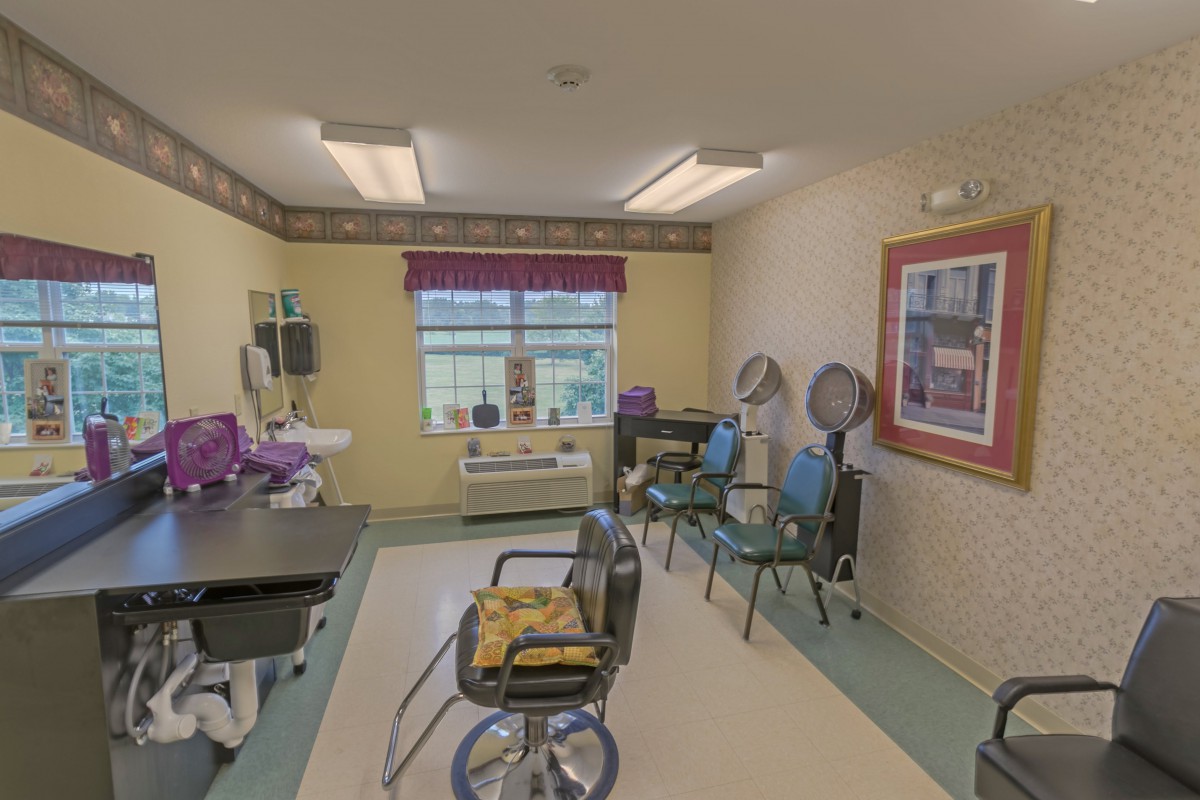 Interior of a salon with chairs and hair drying stations.