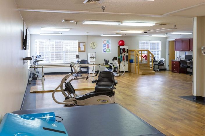A spacious gym with various exercise equipment and a workout area.