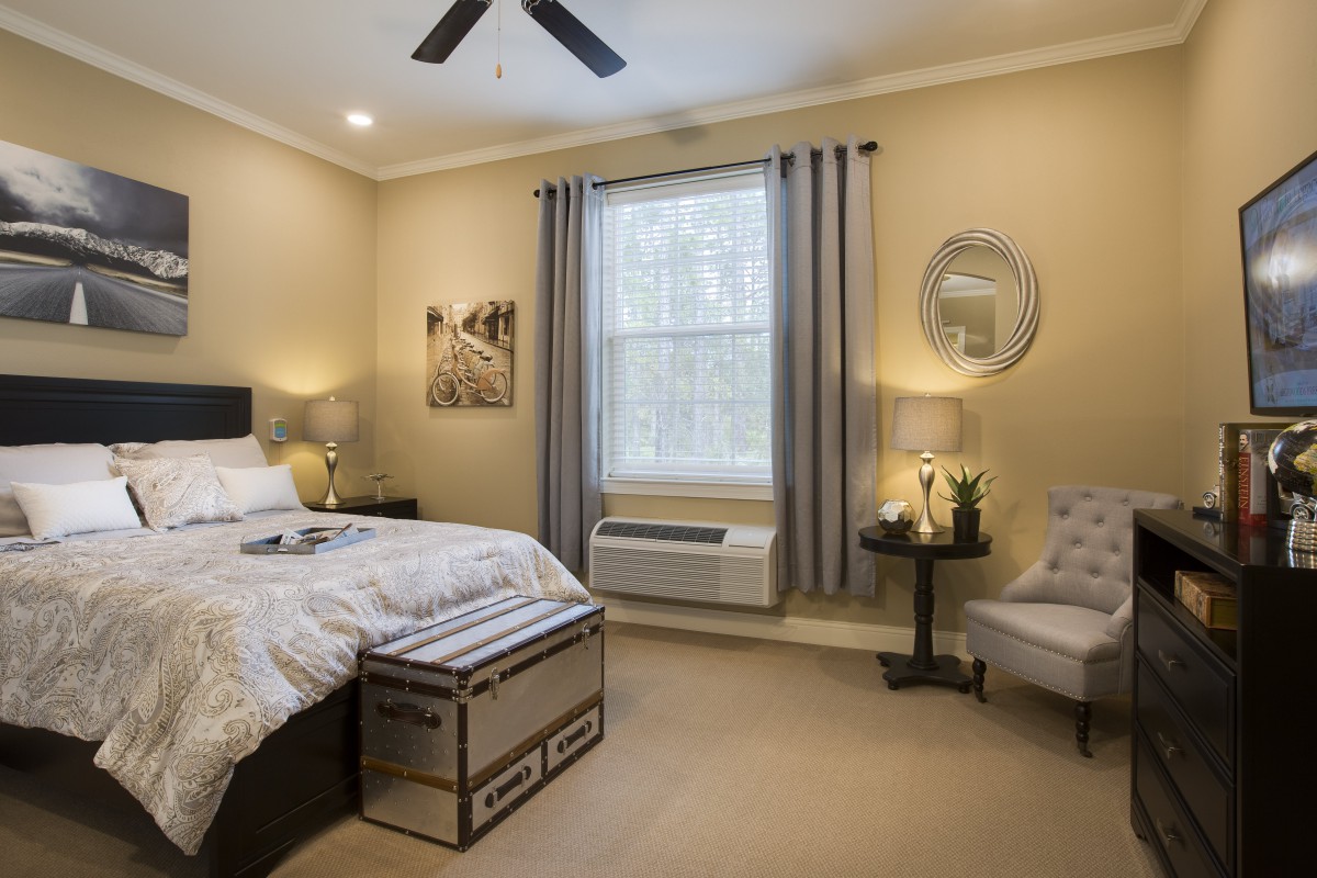 A modern bedroom with neutral colors, featuring a bed, nightstands, and stylish decor.