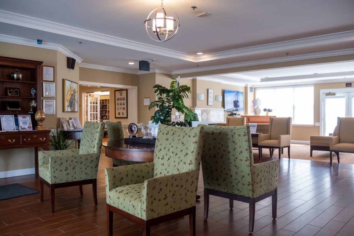 A cozy lounge area with patterned chairs, wooden flooring, and decorative elements.