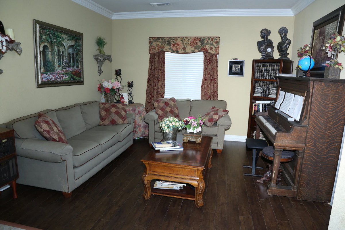 A cozy living room with a piano, sofas, and a wooden coffee table.