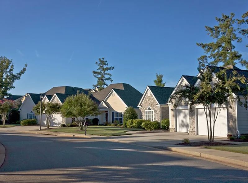A row of suburban houses in a quiet residential neighborhood during the day.