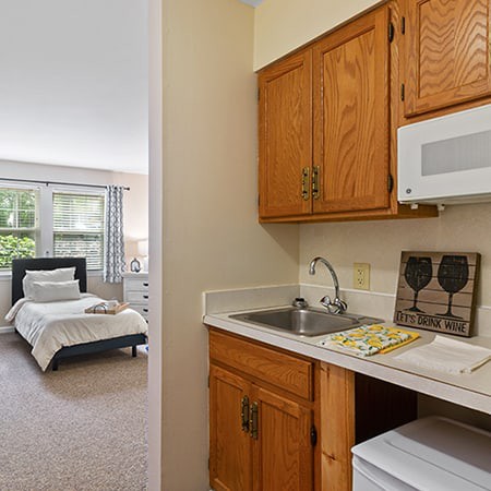 A cozy studio apartment with a kitchenette and visible bedroom setup.