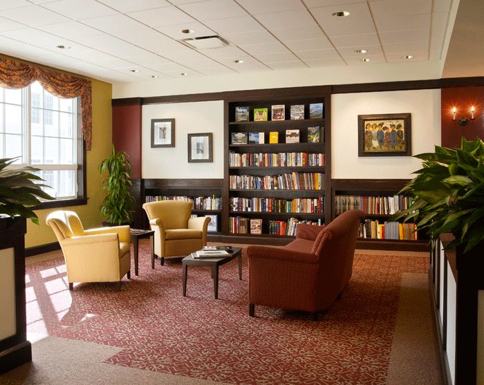 A cozy reading area with armchairs and a bookshelf filled with books.
