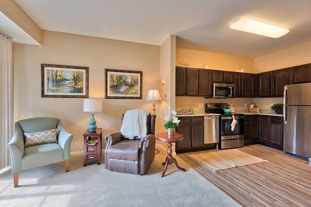 A cozy apartment with an open living room and kitchen area, featuring modern decor and comfortable seating.