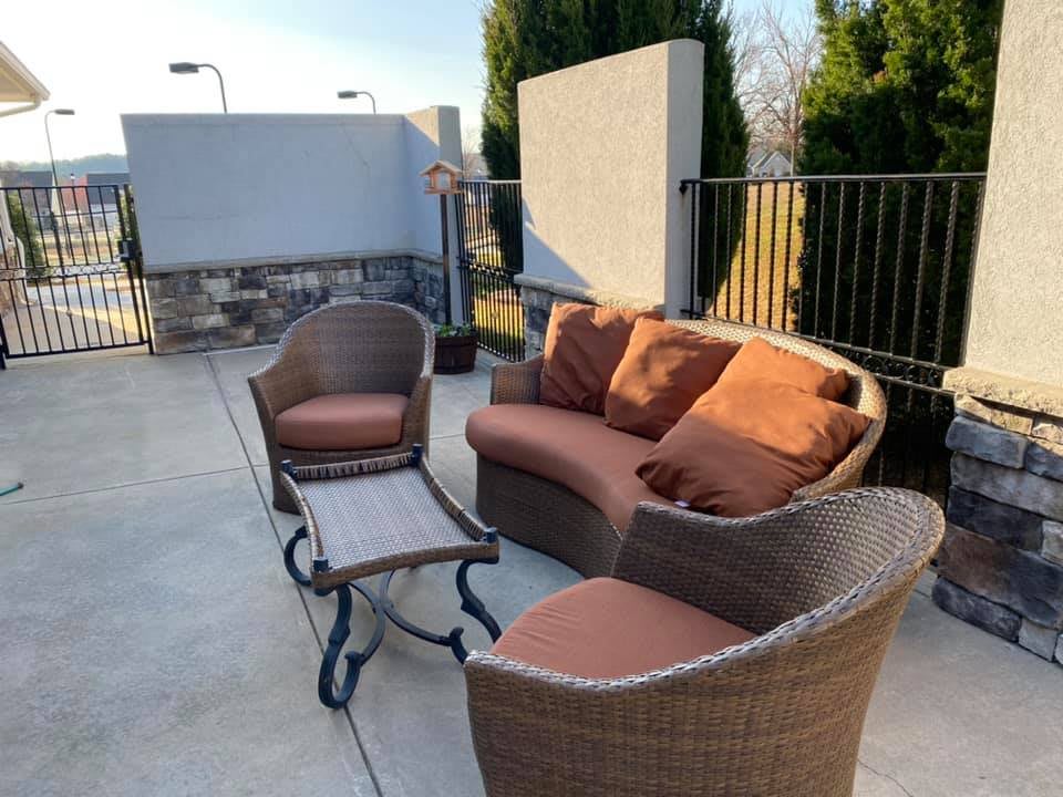 A cozy outdoor seating area with wicker furniture and cushions.