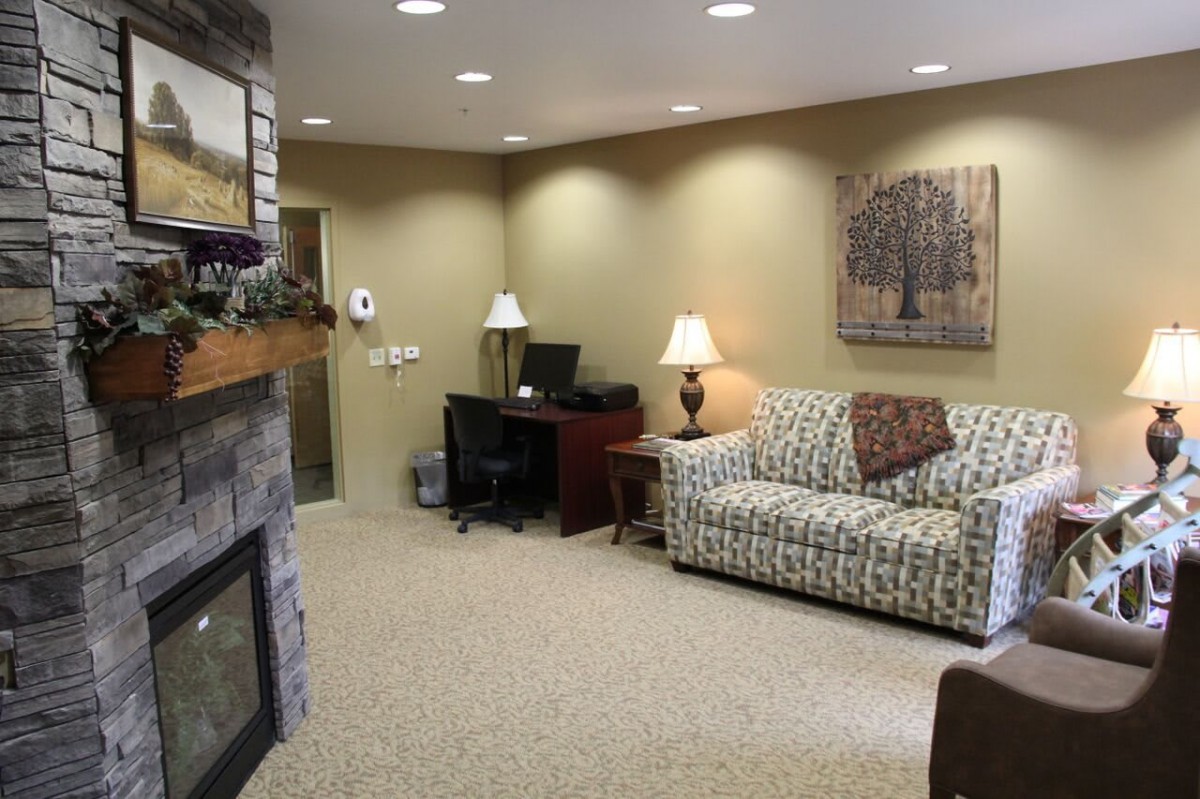 A cozy living room featuring a patterned sofa, a fireplace, and ambient lighting.