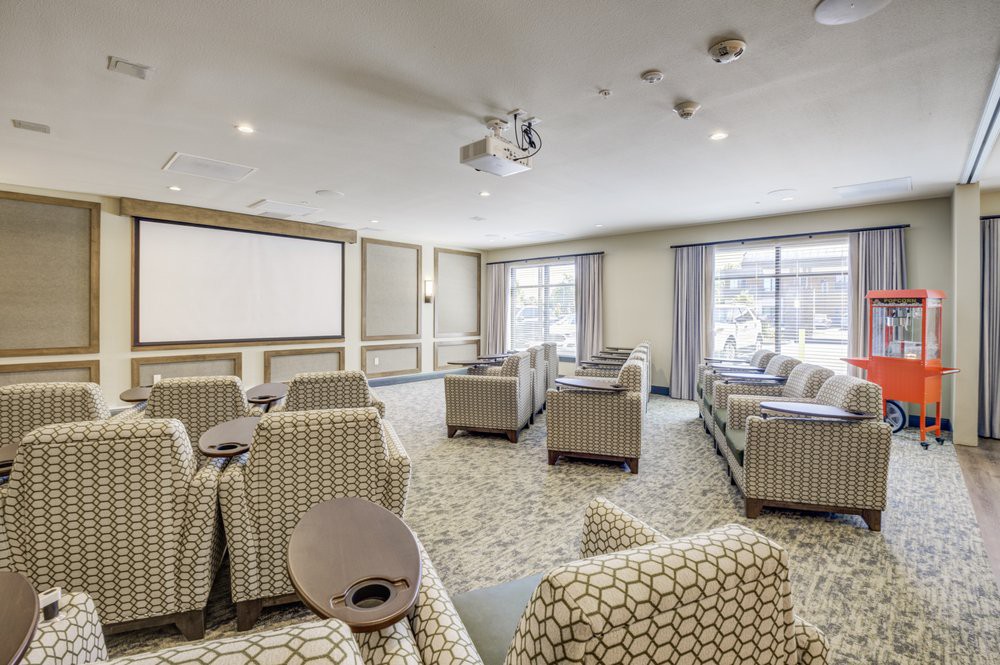 A modern conference room with comfortable seating and a large projector screen.