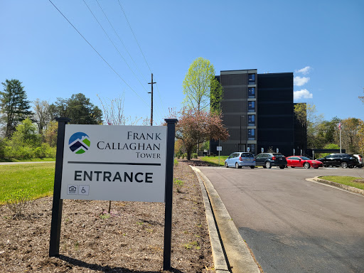 Entrance to Frank Callaghan Towers, featuring a clear blue sky and surrounding greenery.