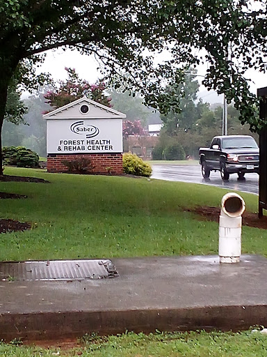 A rainy day view of a sign for a wellness center alongside a road.
