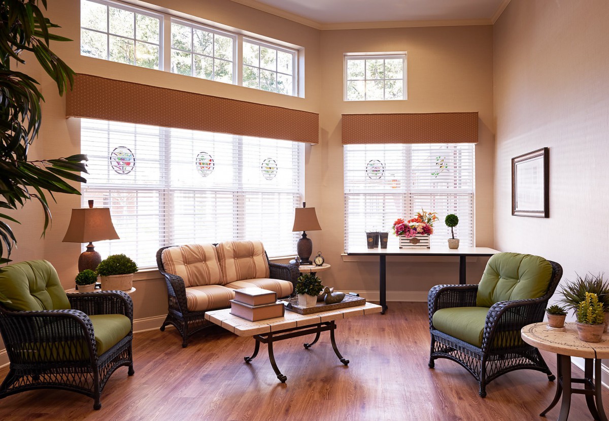 A cozy living room with ample natural light, featuring comfortable seating and tasteful decor.