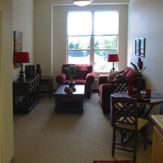 A cozy living room with a sofa, coffee table, and large window.