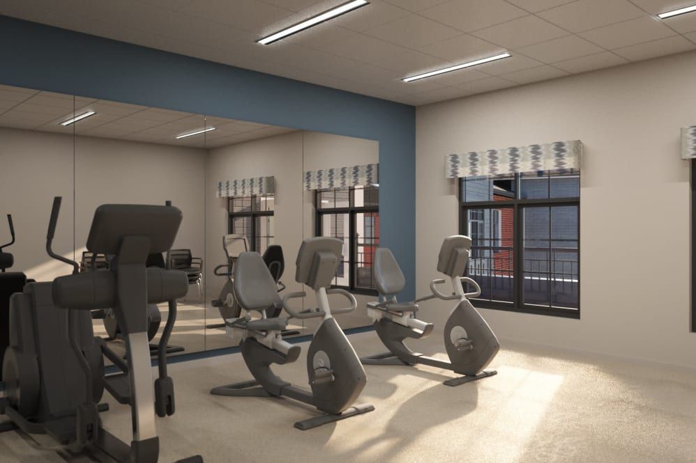 A clean and modern gym with stationary bikes and a treadmill.