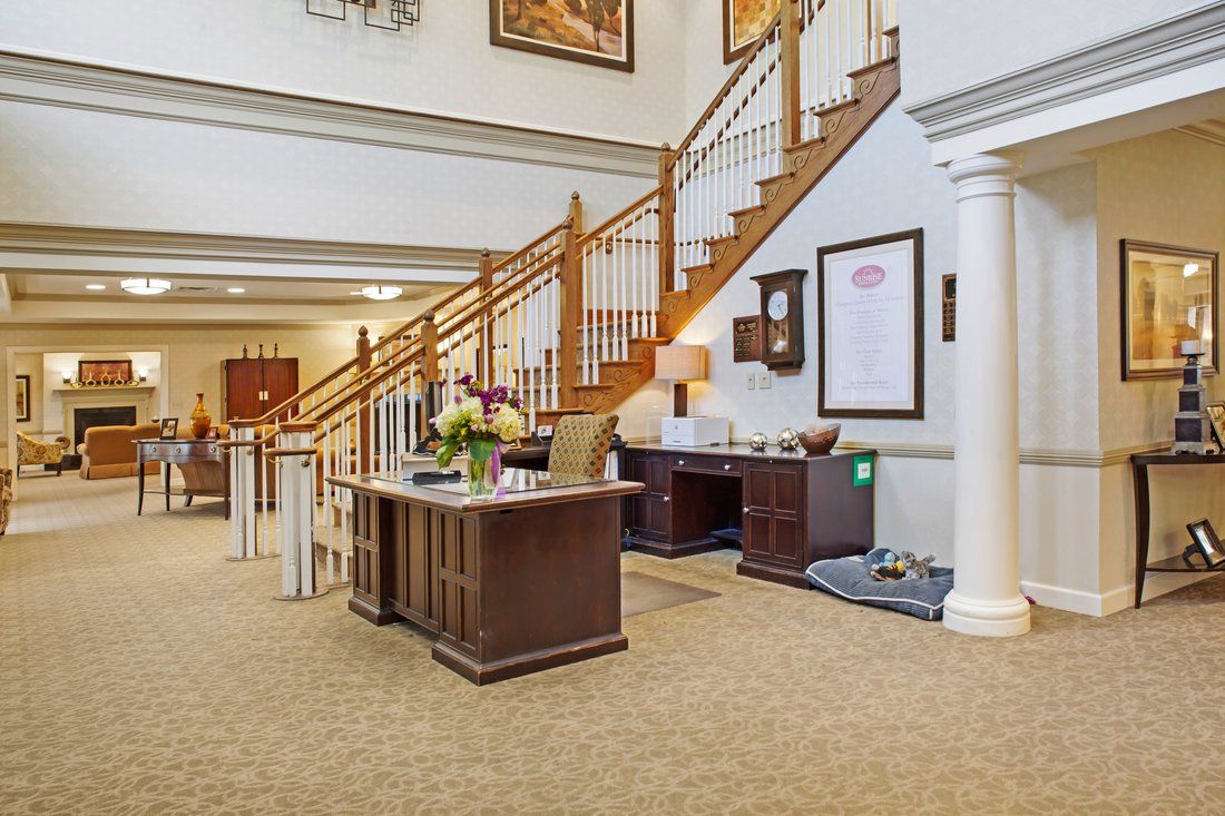 A spacious and elegantly decorated lobby with a central staircase and reception desk.