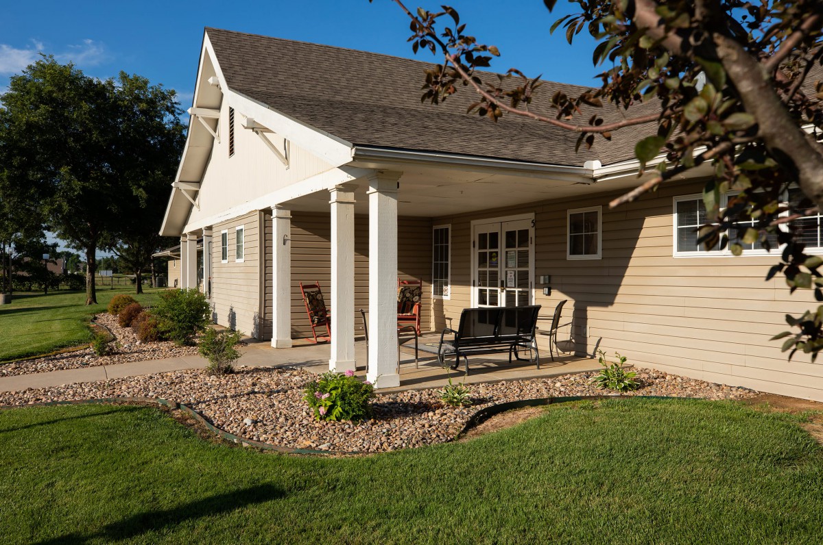 A sunny view of a house with a patio and garden area.