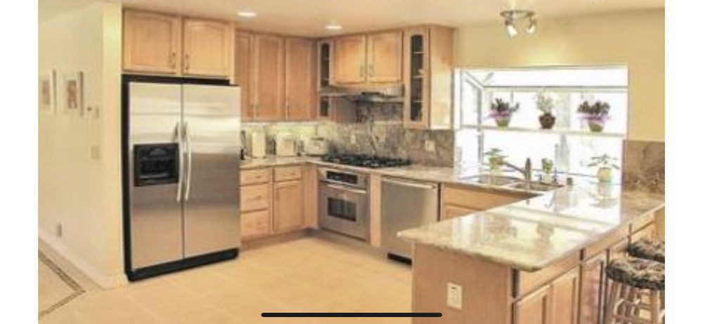 A modern kitchen with stainless steel appliances and wooden cabinets.
