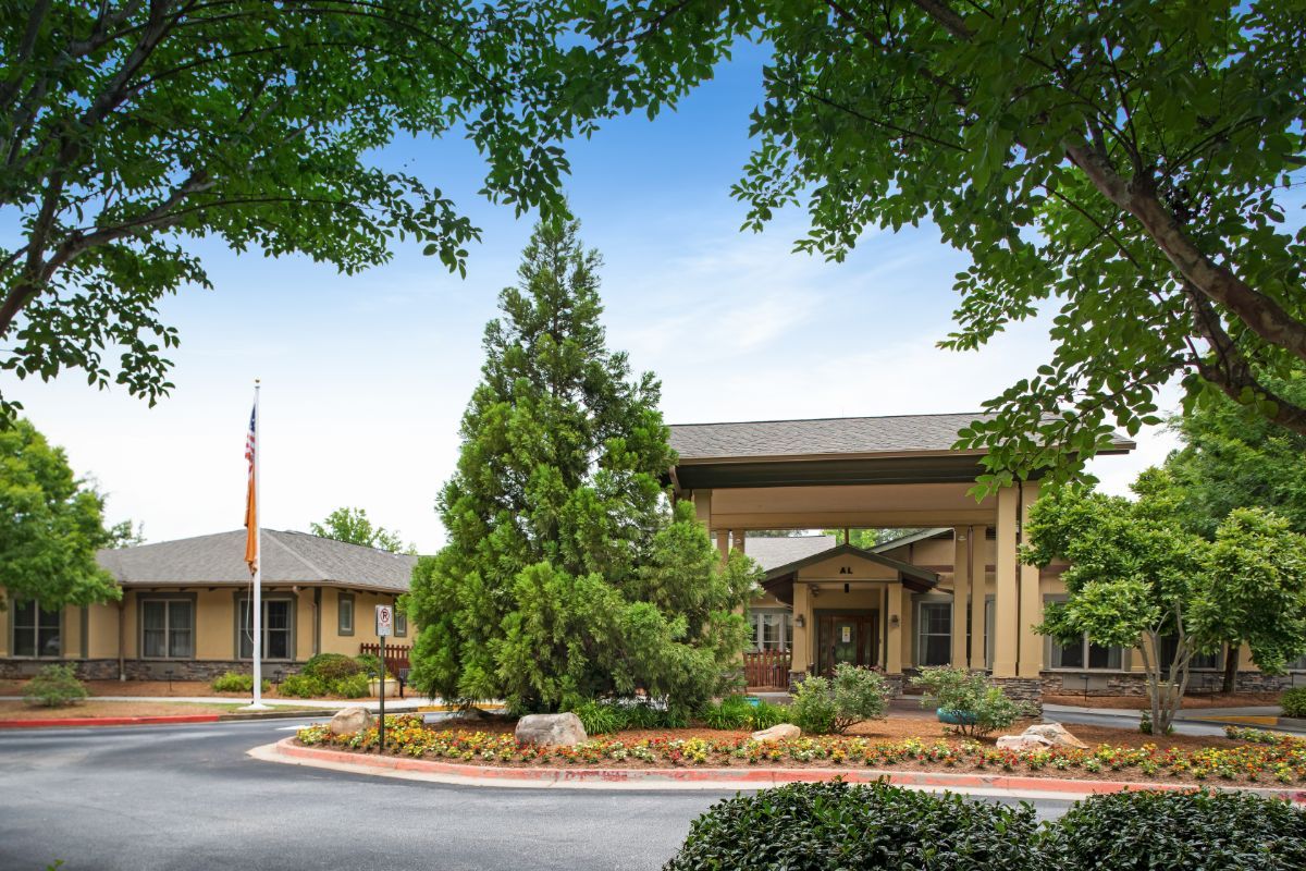A building entrance surrounded by trees and a circular driveway.