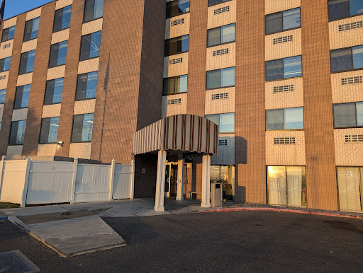 A view of the entrance to a modern brick building with large windows.