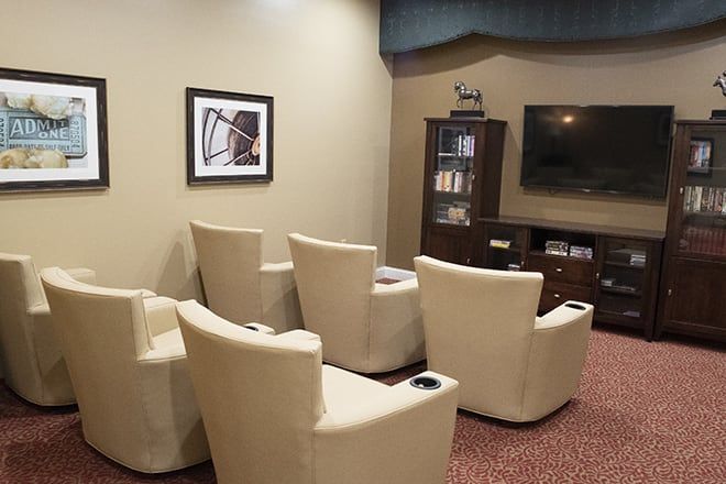 A modern lounge area featuring comfortable seating and a large television.