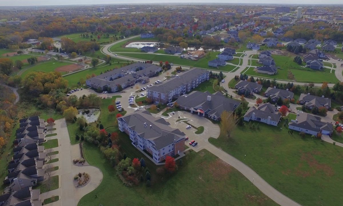 Aerial view of a residential complex surrounded by greenery and roads.