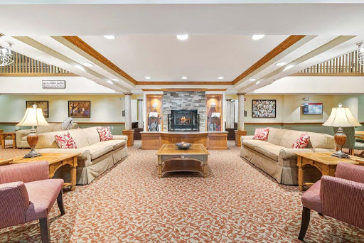 A cozy and inviting living room featuring comfortable seating, a charming fireplace, and decorative artwork.
