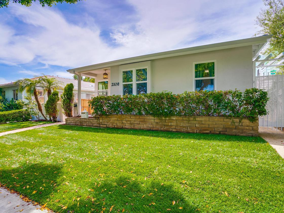A well-maintained suburban house with a lush green lawn and landscaping.