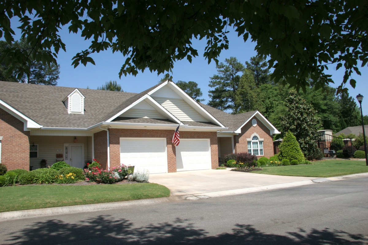 A suburban brick house with a two-car garage and well-maintained landscaping.