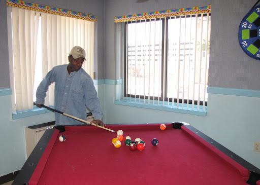 A man skillfully lining up a shot at a pool table.