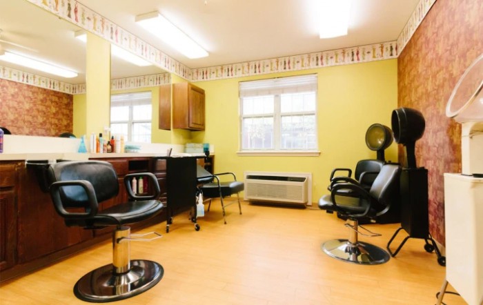 A bright and clean hair salon interior with several styling chairs and mirrors.