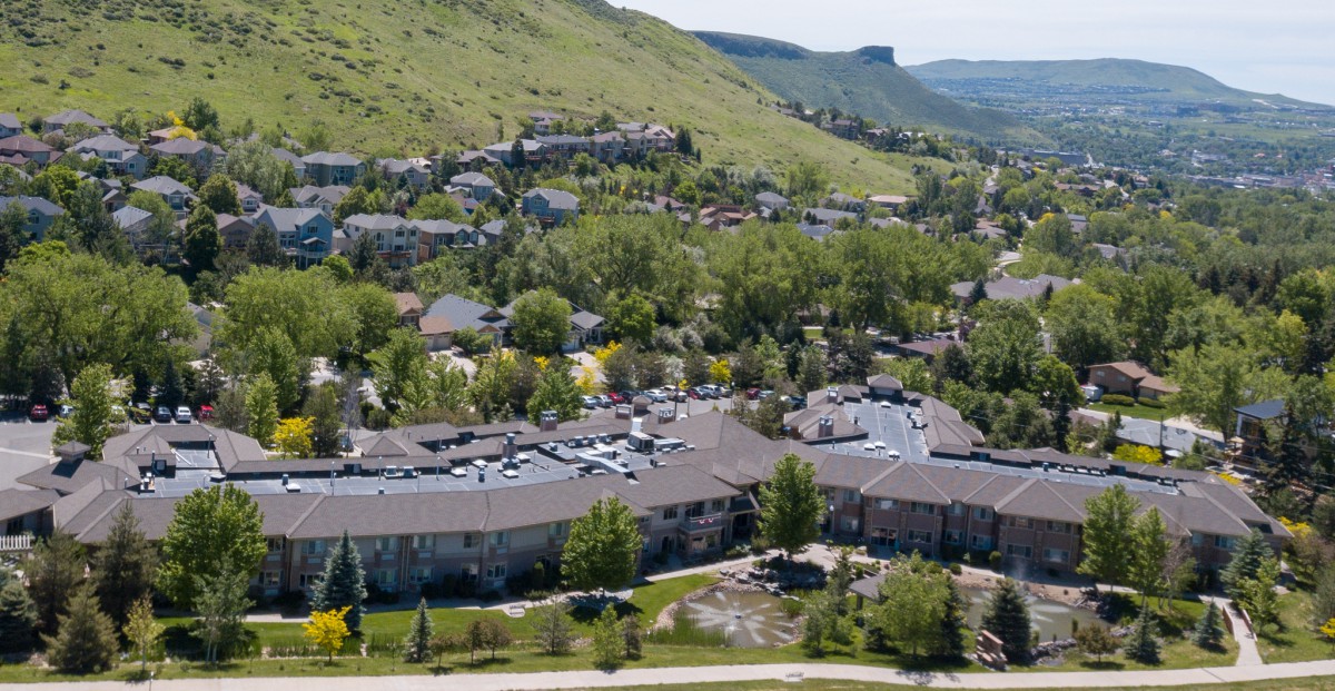 Aerial view of a residential area surrounded by trees and hills.