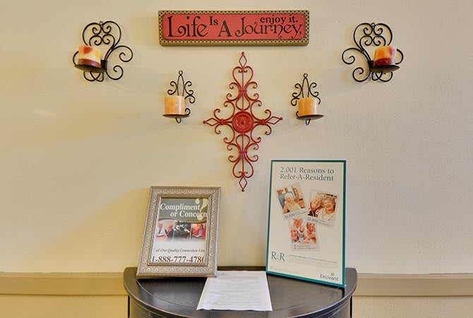 A decorative wall display featuring candles, framed signs, and an inspirational quote.