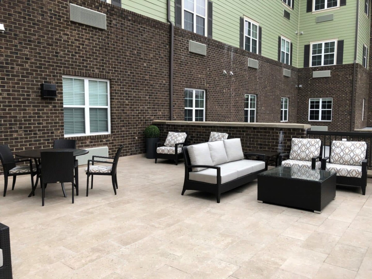 An outdoor patio with comfortable seating arrangements in an apartment complex.