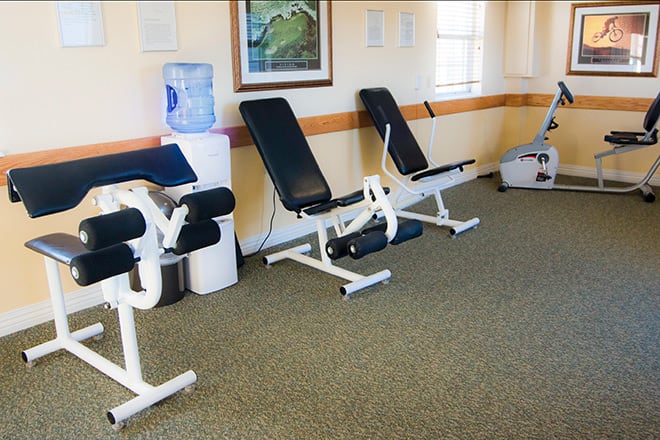 A small gym space featuring exercise machines with cushioned benches.