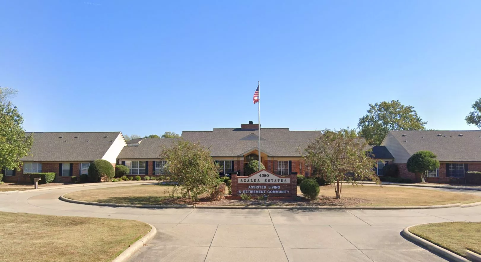 A single-story school building with a flagpole and landscaped surroundings.